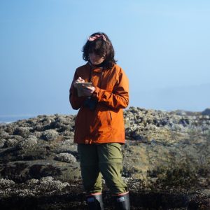Kaper Greenfield stands in a tide pool and takes notes
