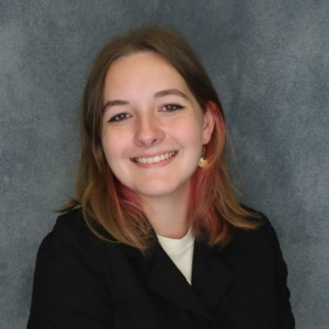 Haylee Weisner smiles in front of a blue-gray background.