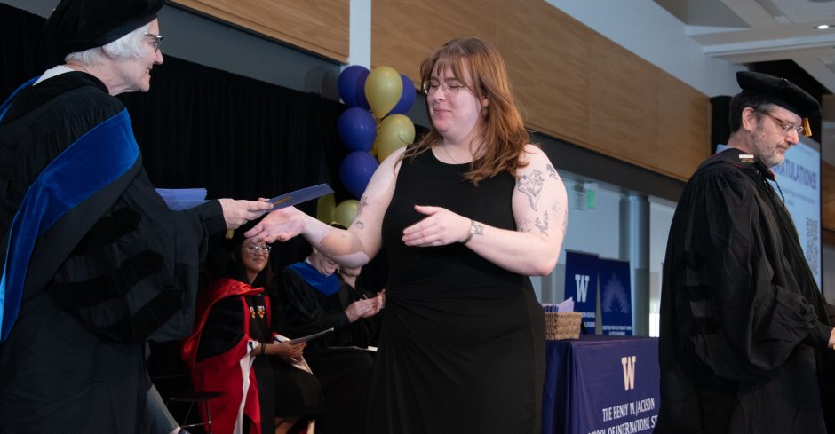 Mai Kearney receives her master's degree at the 2026 Jackson School Spring Convocation on June 13, 2026. To the right is Jackson School Japan Studies Program Chair and Professor Robert Pekkanen. Photo by Kerry Dahlen