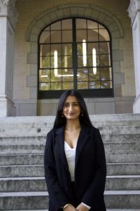 Woman in black gown infront of a building. 