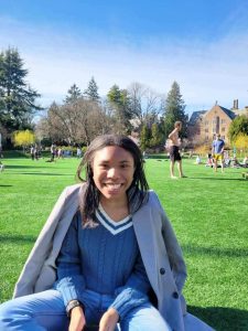 Smiling woman sitting on grass on UW Campus