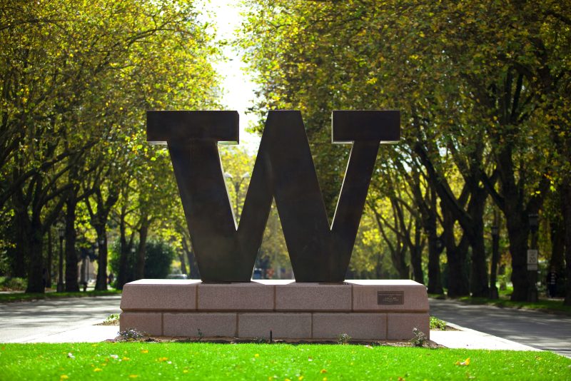Bronze block W that stands at entrance to UW on NE 45th Street. In background is Memorial Way. Fall.